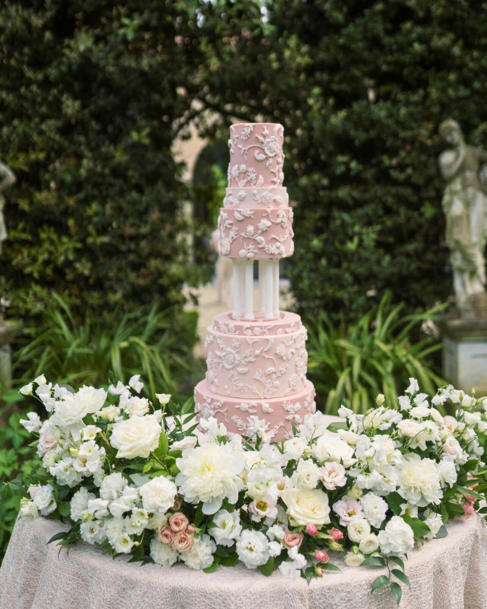 Tall wedding cake displayed using Prop Options column cake separator with soft pink floral decoration from Eruzlie cake
