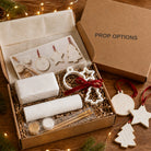 Family Christmas clay bauble kit in a kraft box stamped with the Prop Options logo, with clay, reeded roller, cutters, ribbon and paints