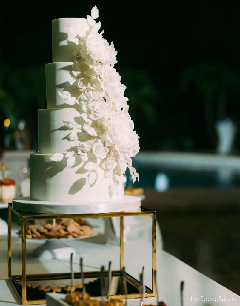 Gold Square Metallic Plinth holding up a tall white wedding cake covered in white flowers - Prop Options
