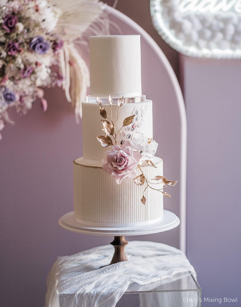Plain white wedding cake with subtle floral decorations on the front, the tiers are separated using 15mm Acrylic Cake Separators - Prop Options