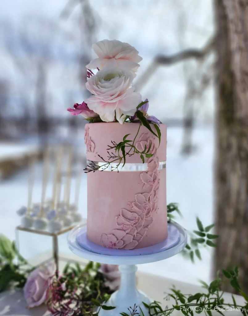 Pastel pink two layer cake covered in pink and purple florals, the cake layers are separated by a 15mm Acrylic Cake Separator - Prop Options