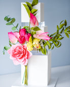 A white square cake with pink and yellow flowers with a 30mm Square Acrylic Cake Separator between each layer - Prop Options