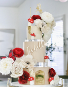 Cream coloured three tier fairytale cake with red and white flowers, fake mushrooms, a red butterfly, and gold fairy topper, each tier is separated by a 30mm Round Acrylic Cake Separator - Prop Options