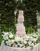 Tall wedding cake displayed using Prop Options column cake separator with soft pink floral decoration from Eruzlie cake 