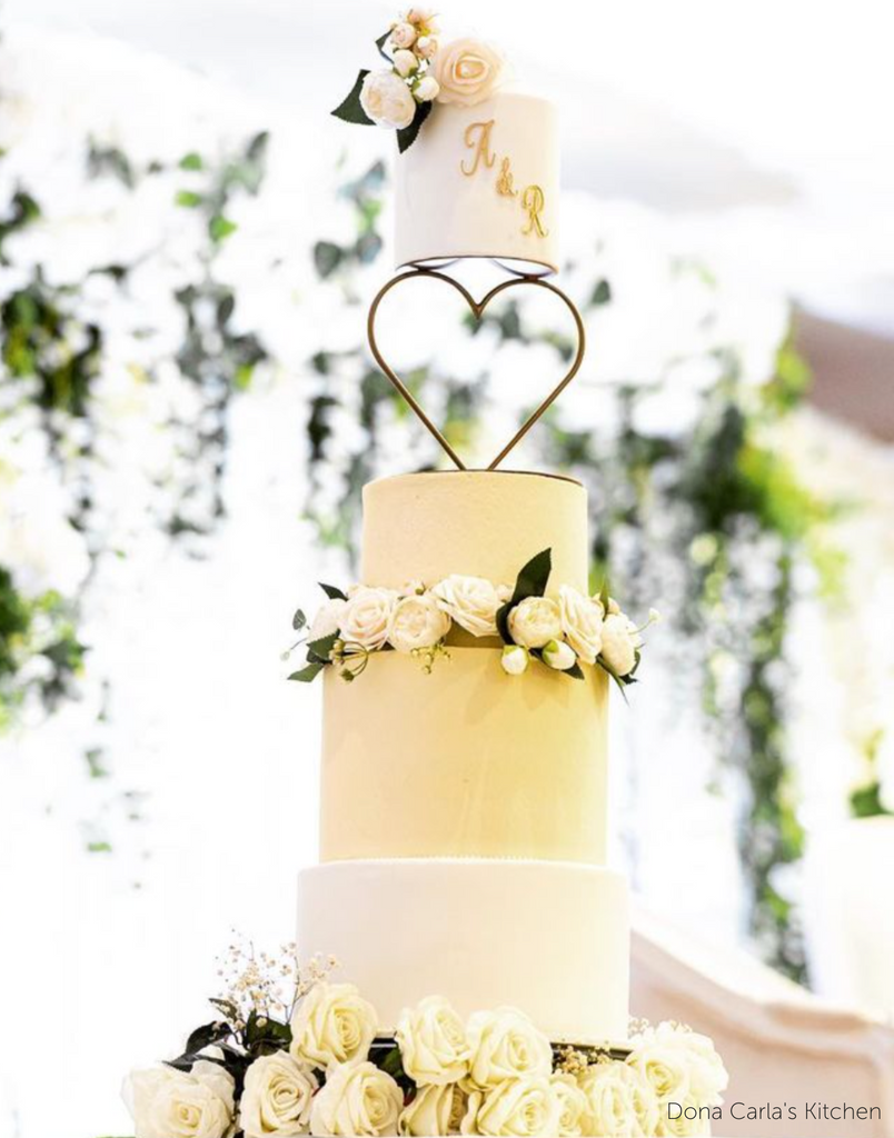 Cream and light yellow four tier cake with white roses, the top two layers are separated by a Heart Tier Separator - Prop Options
