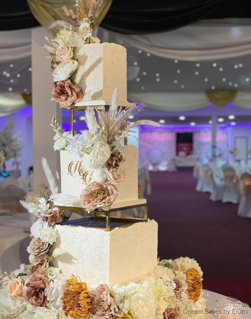 A white cake with light coloured flowers being separated using Square and Rectangle Metallic Cake Spacers - Prop Options