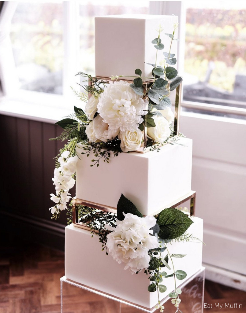 A white cake with white flowers separated using Square and Rectangle Metallic Cake Spacers - Prop Options