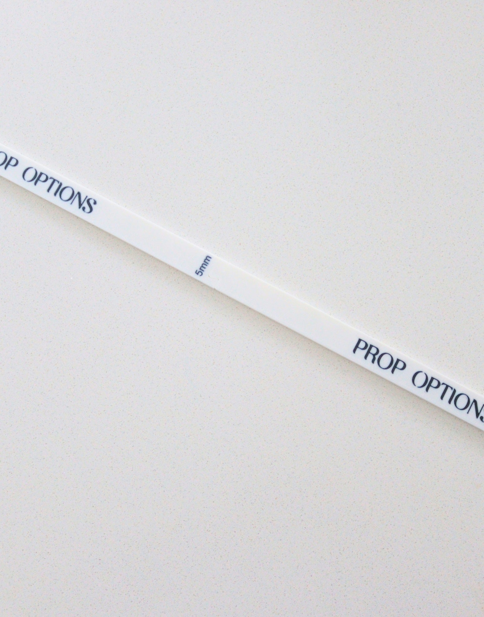 White ruler with 'PROP OPTIONS' text on a beige background