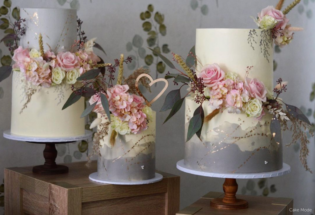 Three white and grey floral cakes stood on a trio of Original Scandinavian Birch Cake Stands - Prop Options